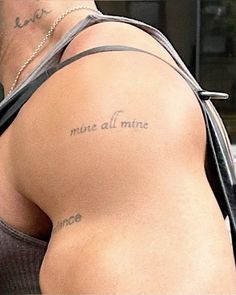 the back of a man's arm with tattoos on it and words written in cursive writing