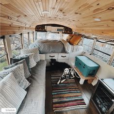 an interior view of a camper with wood ceiling and bed in the center area