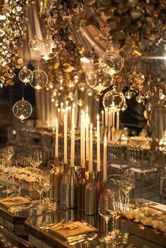 an elaborate table setting with candles and crystal balls in the center, surrounded by gold plates and napkins