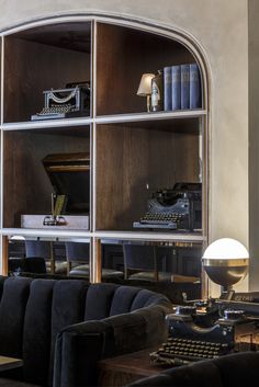 a living room filled with furniture and a typewriter on top of a wooden shelf