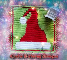 a crocheted christmas stocking design with lights and snowflakes in the background