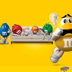 the m & m's characters are sitting on a couch