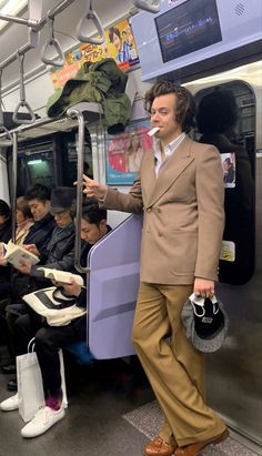 a man in a suit standing on a subway train