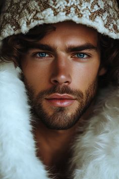 a man with blue eyes wearing a white hat and fur coat is looking at the camera