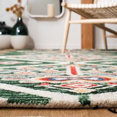 a green and white rug on the floor in front of a chair with a mirror behind it