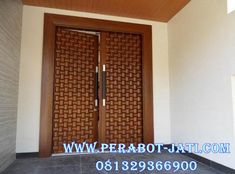 two wooden doors in front of a white wall