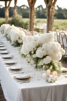 a long table with white flowers and candles