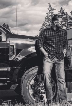 a black and white photo of a man standing in front of a truck with the words haan haige aa on it