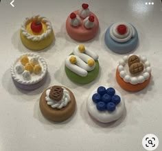 there are many small cupcakes on the counter top, all decorated in different colors