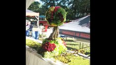 a tree made out of flowers is on display at an outdoor event in the park