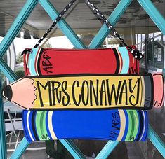 a sign that says mrs conaway hanging from a blue metal frame in front of a window