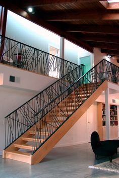 an open floor plan with stairs leading up to the second floor and bookshelves