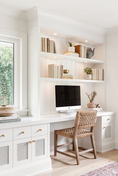 a home office with built in bookshelves, desk and chair by the window