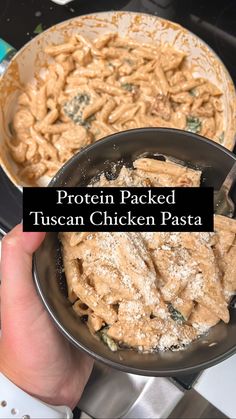 a person holding a pan filled with pasta in it's hand and the words protein packed tuscann chicken pasta