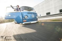 a blue vw bus driving down the road