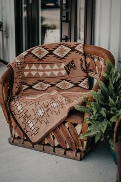 a brown chair sitting on top of a wooden floor next to a potted plant