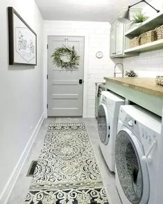 a washer and dryer in a small room with tile flooring on the ground