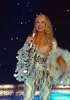 a woman standing on top of a stage holding a microphone