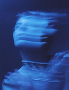 a blurry photo of a woman's face with blue light in the background