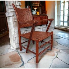 two wooden chairs sitting next to each other in front of a brick wall and fireplace