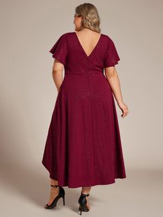 a woman in a red dress is looking back at the camera and she has her hands on her hips