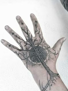 a person's hand with a tree tattoo on it