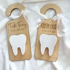 two wooden tooth shaped magnets on a white sheet