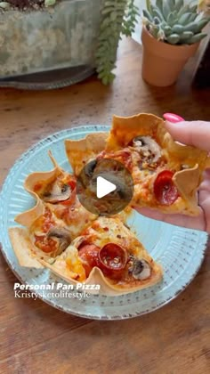 a person is holding a slice of pizza on a plate with mushrooms and pepperoni