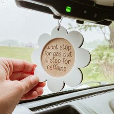 a person holding up a sign that says, won't stop for gas but it'll stop for caffeine