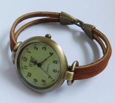 This is an unusual casual watch for woman. The watch head is made in alloy, free of nickel and lead, aged bronze finish, round shape, 1.25 inches diameter. The wristband is made with two piece of genuine oil tanned leather, treated with a protective coating to make it tear resistant and fire resistant. This kind of leather is the same used on logger boots. The closure is made in alloy, also aged bronze finish, folding over type. Comes in 8 sizes:   XS    for a 6.00 inches wrist      S    for a 6 Cheap Leather Watch Accessories, Cheap Brown Watch Accessories For Gift, Cheap Everyday Brown Watches, Cheap Retro Analog Watch Accessories, Cheap Brown Watches, Cheap Brown Everyday Watches, Cottagecore Wrist Watch, Vintage Watch Claw, Luxury Vintage Handmade Watch Accessories