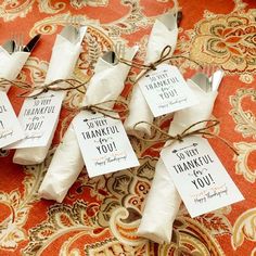 small white bags tied with twine on top of an orange and gold table cloth