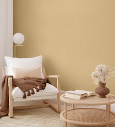 a living room with a chair, coffee table and vase filled with flowers on it