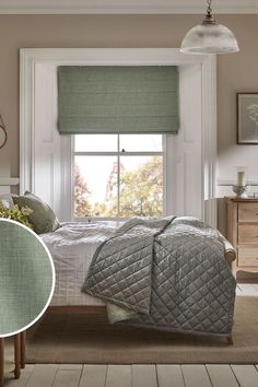 a bed sitting under a window in a bedroom