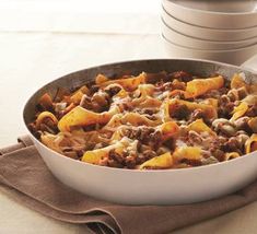 a skillet filled with pasta and meat