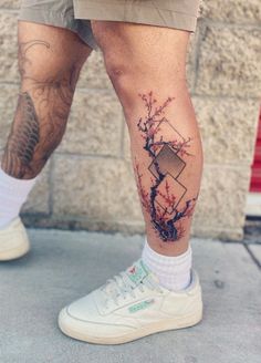 a man's legs with tattoos on them and an apple tree in the middle