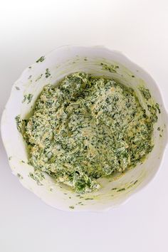 a white bowl filled with spinach and cheese