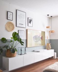 a living room filled with furniture and pictures on the wall