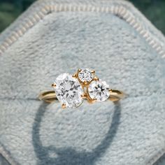 three stone diamond ring sitting on top of a cushioned surface in front of a white towel