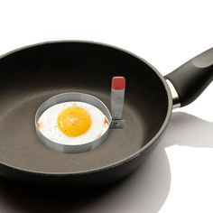 an egg in a frying pan with a red pepper sticking out of the side