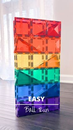 a stack of colorful plastic blocks sitting on top of a wooden floor