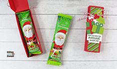 two christmas crackers are sitting next to each other on a white wooden surface, one is green and the other is red