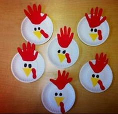 paper plates with chicken faces on them are arranged in the shape of handprints