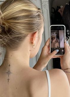 a woman taking a selfie in front of a mirror with her cell phone up to her ear