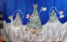 an image of a stage set with christmas trees and angels on the curtained walls