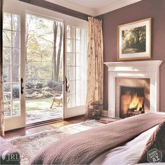 a bedroom with a fireplace and large windows