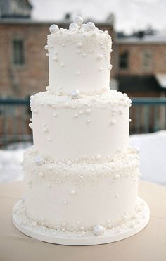 a wedding cake with white flowers on the table