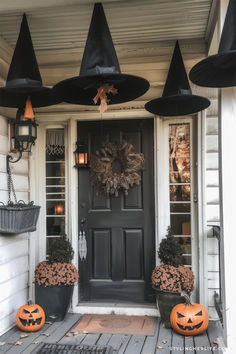 a front porch decorated for halloween with pumpkins and witches hats