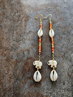 Long Cowrie Shell Beaded Orange Earrings, Elephant, Wire Wrap, Bohemian Jewelry,  Dangle Earrings Orange multicolor beads, Agate elephant beads, Cowrie shells, 5" length, light weight. Still shopping? Wonderful. www.etsy.com Gold Earrings With Latkans For The Beach, Gold Latkans Earrings For Beach, Gold Latkan Earrings For The Beach, Bohemian Beaded Earrings With Latkans For Beach, Bohemian Beaded Latkans Earrings For Beach, Bohemian Beaded Latkan Earrings For Beach, Beach Earrings With Latkans, Bohemian Latkans Earrings For Beach, Drop Earrings With Latkans For Beach