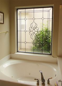 a bath tub sitting under a window next to a sink and shower faucet