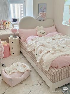 a bedroom with pink and white bedding and teddy bears